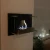 Chimenea de bioetanol de pared negro con cristal de seguridad. Su peso de 10kg lo hace fácil de montar.